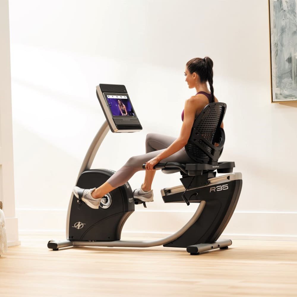 Moteris sportuoja su NORDICTRACK R35 horizontaliu dviračio treniruokliu namuose